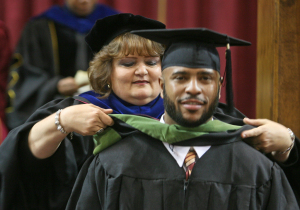 Deborah Garrison, associate vice president for academic affairs and dean of the graduate school, presents hoods to the recipients of master's degrees at Midwestern State University graduation, Wichita Falls Multi-Purpose Event Center, Dec. 14, 2013. Photo by Ethan Metcalf.