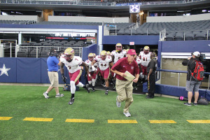 Head football coach Bill Maskill leads the football team onto the field of AT&T Stadium for the start of the game, Sept. 19. MSU defeated Eastern New Mexico University, 28-24. Photo by Rachel Johnson