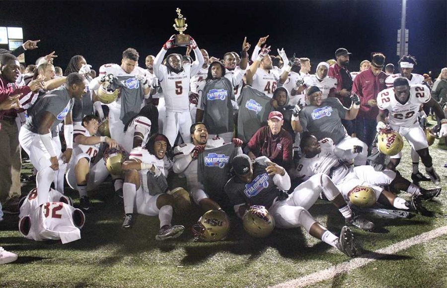 The football players celebrate their victory in the Lone Star Conference Championship game against Texas A&M-Commerce, by posing for a group photo while Brandon Gordon, education senior, holds up the trophy, Nov. 14. 