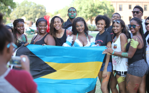 Students gather together to take a group photo with a Bahamas flag in the Killingsworth Green Space for the 2015 Caribfest Parade on Sept. 25.