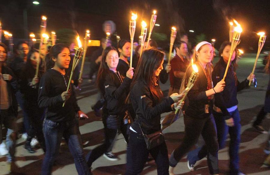 The cross country team carries their torches in the torchlight parade, an event part of Homecoming week, starting on Comanche Trail by the Daniel building, Oct. 29. Photo by Rachel Johnson