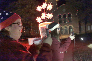 Kinsey McCloud, undeclared freshmen, and Morgan Sinclair, sociology freshmen, take a pictures of the Fantasy of Lights displayed in front of the Hardin Administration Building on Nov. 30. Photo by Kayla White.
