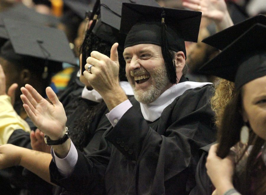 Andrew Herbert, clinical mental health, applauds his family members in the audience during the part in the ceremony where they have the graduates recognize their friends, family, professors, and people who helped them get to graduation day in Kay Yeager, Dec. 12.