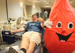 Jase Keister, criminal justice freshman, laughs at the Texas Blood Institute blood drop mascot while giving blood in Comanche suite, Jan, 26, 2016. Photo by Francisco Martinez