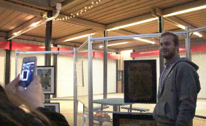 Tyler Colley, graphic design junior, getting a picture taken of him next to his recreation of Wichita Falls at the Graphic Design Pop-up Exhibit at the Wichita Falls Downtown Farmer's Market on Jan. 26th. Photo by Kayla White.