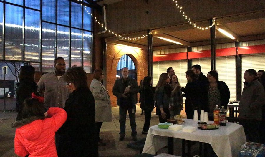 Group of attends conversing at the Graphic Design Pop-up Exhibit at the Wichita Falls Downtown Farmers Market on Jan. 26th. Photo by Kayla White.
