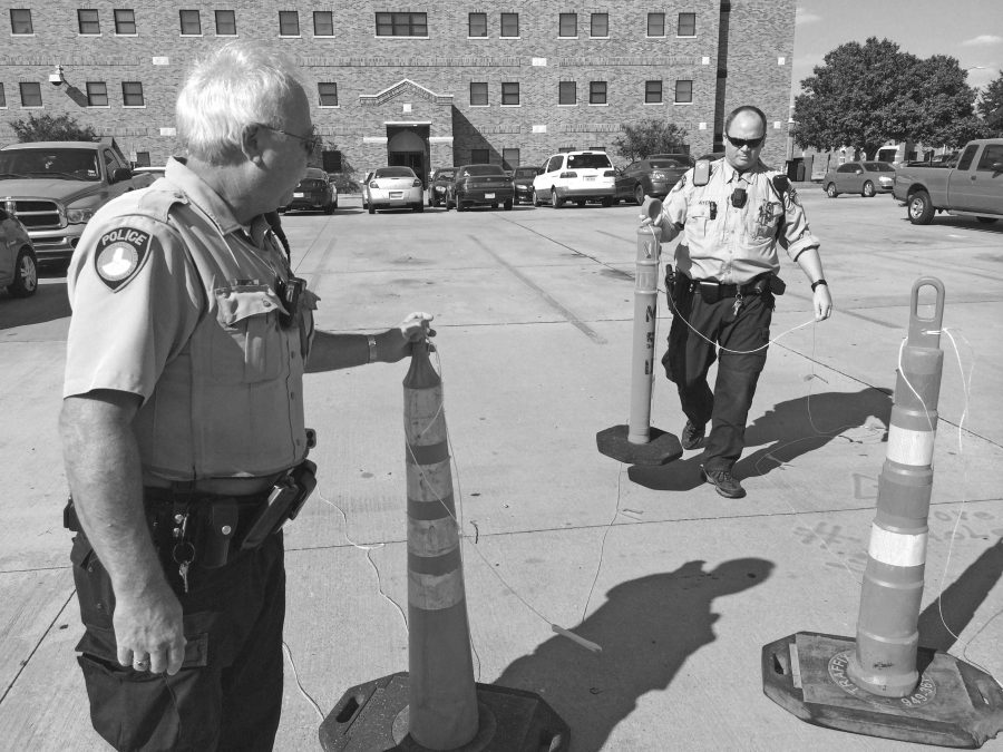 Officers Mark Gilbow and Chris Aten move traffic cones in what used to be a residential parking lot between McCullough-Trigg Residence Hall and Fain Fine Arts building. The space is now home to the construction of the newest residence hall. 2014 file photo by Ethan Metcalf