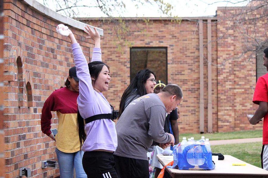 Ann Tran, art freshman and human, celebrates about getting past the first part of the second mission during a campus-wide game of Humans vs. Zombies. She will later be turned into a zombie in her attempt to escape the base and make it to a safe zone. Photo by Rachel Johnson