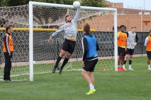Noah Fazekas, mass communication junior, punches the ball away from the net during practice held on the Midwestern State Soccer Fields. Photo by Harley Warrick