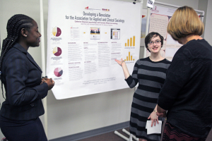 Accounting and sociology senior Careisha Whyte and junior Catherine Stepniak talk to spectators at the poster presentations Thursday. The two won first place for their poster presentation. Photo by Topher McGehee