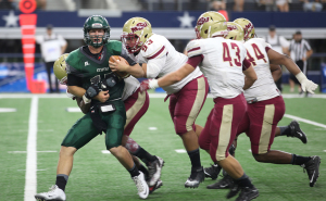 Jeremy Buurman, Eastern New Mexico University quaterback, is sacked and push Emerson Evans, business management junior, and Darian Childers- Brown, kinesiology junior, during the second half of the ENMU vs. MSU game at AT&T Stadium, Sept. 19. Photo by Francisco Martinez