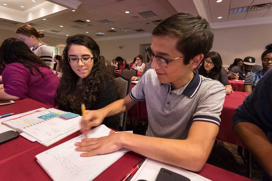 Christopher Cruz, theater performance sophomore, and Maria Isabel Pena, political science junior, talk with each other at the student government meeting Oct. 4. Photo by Izziel Latour