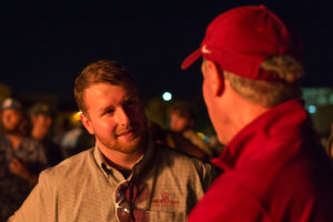 Jessie Brown, graduate student, talks to head football coach Bill Maskill at the Homecoming bonfire Oct. 27. Photo by Izziel Latour