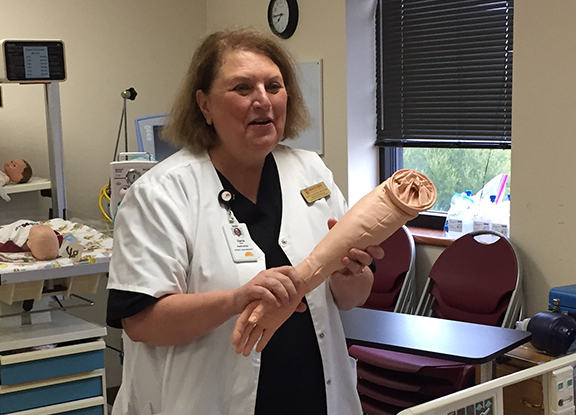 Daria Close, assistant nursing professor, holds up the arm of the mannequin as they run through the motions of the adult code on Nov. 8, 2016.