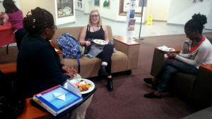 Psychology grad students Kietha Peters, Alyssa Morse, and Miriam Boateng enjoy their food at the International Potluck Monday night.