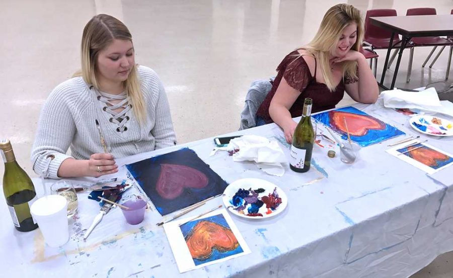 Natalie Griffin and Hannah Sommerhauser drink wine and paint hearts at the exploring arts acrylics class. Photo by Caleb Martin