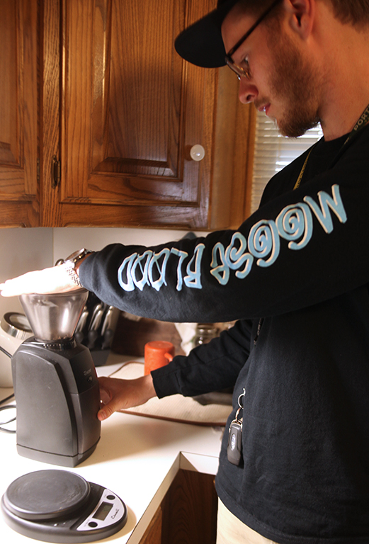 Mason Wilson, management senior, grinds coffee to be brewed for sampling purposes. March 22. Photo by Arianna Davis