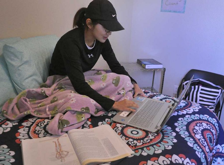 Audrey Beach, exercise physiology graduate, gets comfortable while studying on her apartment bed in Sundance Court. May 5. Photo by Arianna Davis