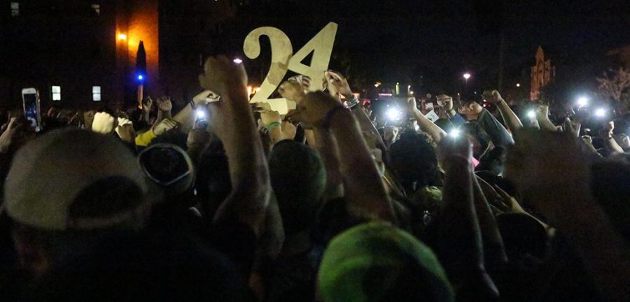 Students holding up No. 24 at the candlelight vigil remembering Robert Greys on Jesse Rogers Promenade on Sept. 21. photo by Elias Maki