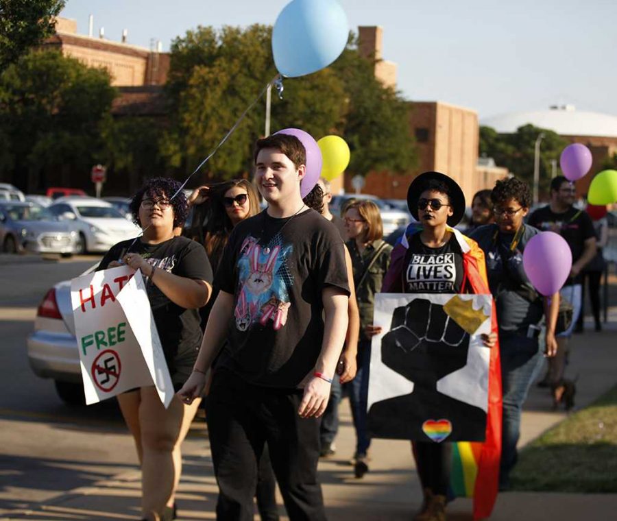 Zarya Maitao, mass communication sophmore, Jessie Tidwell, science education sophmore, and Zaquera Wallace, biology junior, flashes color and march in the Resist Hate Rally held in Sunwatcher Plaza on Sept. 1. Photo by Marissa Daley