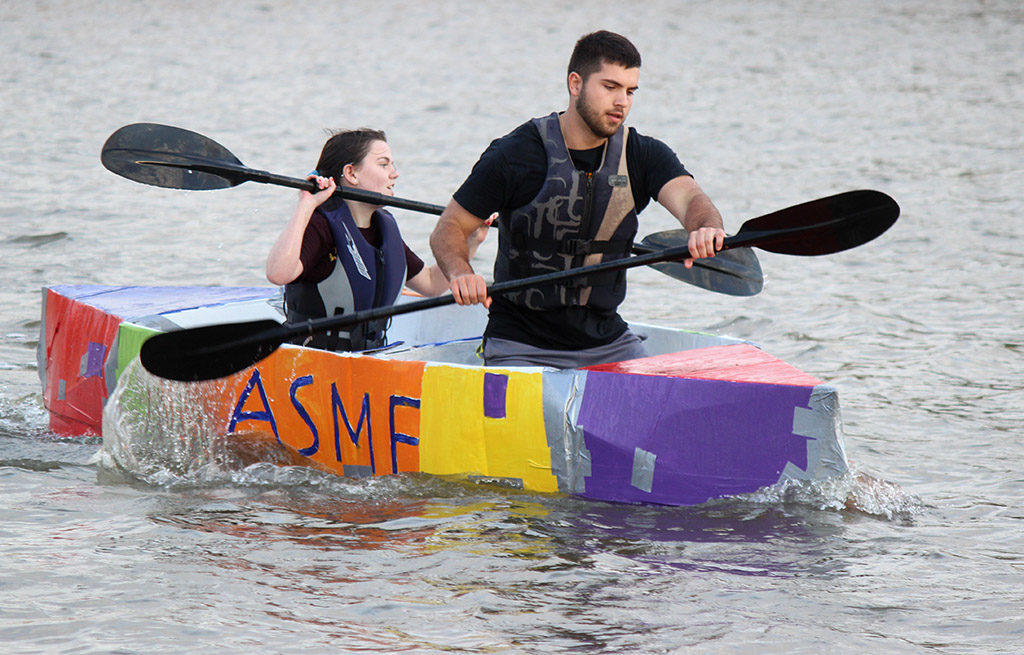 Clayton Masters, mechanical engineer junior, and Kyndal Diehm, mechincal engineer sophomore, take the lead, finishing first in the 2017 Homecoming Boat Race, Friday, Oct. 20. "It was a lot of man hours to get this built. It took 84 and a half hours. It feels great, but i'm going to be taking a long shower after this," Diehm said. Photo by Rachel Johnson
