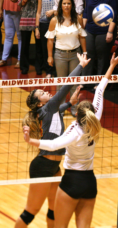 Rockelle Gholson, mass comunication junior, jumps up to block the ball from a Texas Womens University opponent at the womens volleyball game in the D.L. Ligon Coliseum on Sept. 29. Photo by Harlie David