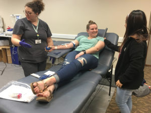 Jessica Hernandez, nursing sophomore, comforts Lauren Tisdale, special education junior, because it is her first time donating blood while Kristin Roberts, mobile supervisor, checks on her at the Clark Student Center Tuesday, Jan. 23, 2018. Photo by Cortney Wood