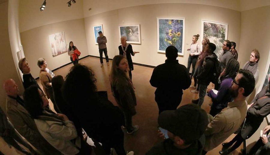 Kenda North, Juanita Harvey Art Gallery guest artist, speaks about her work and the process for individual peices in her gallery during the opening reception, Friday, Feb. 2, 2018. Photo by Francisco Martinez