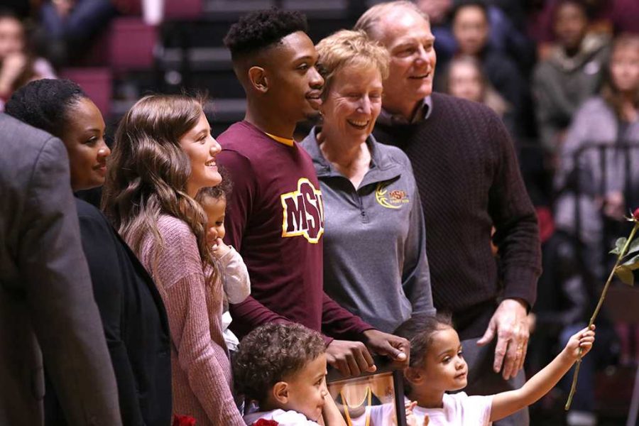 Devante Pullum, criminal justice senior, poses with coaches and family members during the honoring of seniors in between basketball games in D.L. Ligon Coliseum on Feb. 10. Photo by Rachel Johnson