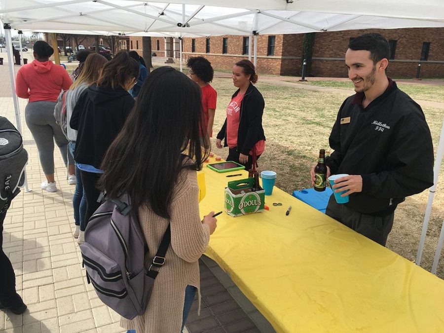 Derek Soper, Legacy Hall director, educates students on how to play the game flip cup. Photo by Tyler Manning.