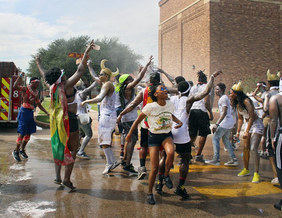 The Wichita Falls Fire Department sprays the participants in the Caribfest Parade while they dance, sung, and ran through it at the end of the parade infront of the Mass Communication building before they headed onto Jesse Rogers Promenade Sept. 30. Photo by Rachel Johnson