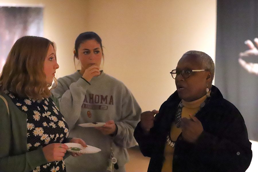 Siany Kloss, art freshman, and Alex Blake, finance senior, talk to artist Victoria Meek during open recitption in the Juanita Harvey Art Gallery on April 6. Photo by Justin Marquart