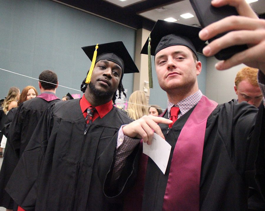 Malachi Smith, kinesiology, and Sam Shirley, kinesiology, take a selfie together while waiting to be taken over to Kay Yeager Coliseum for Commencement, Saturday May 12, 2018. Photo by Rachel Johnson