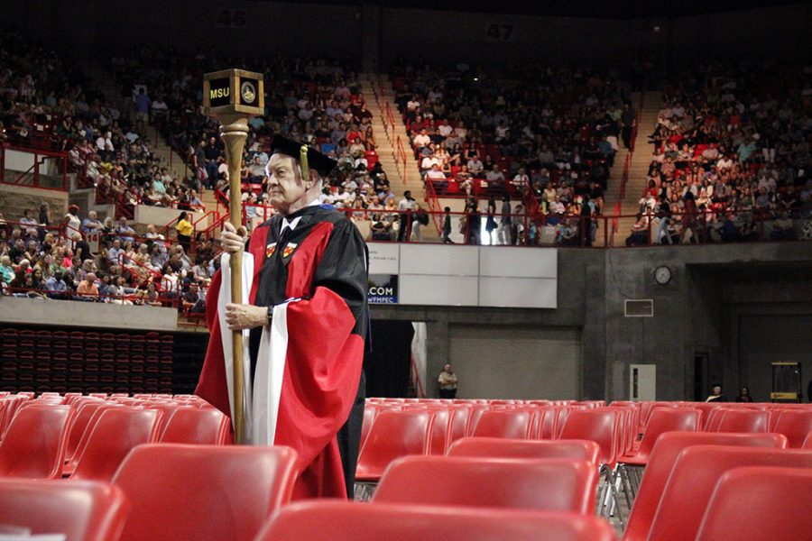 Everett Kindig, history professor, walks with the MSU mace for his last year, as he retired this year after 47 years of teaching at MSU, at Commencement in Kay Yeager Coliseum. Photo by Rachel Johnson