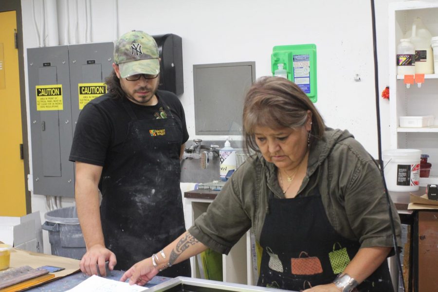 Carlos Aleman, (left) and Melanie Yazzie (right) work on a new screen print.