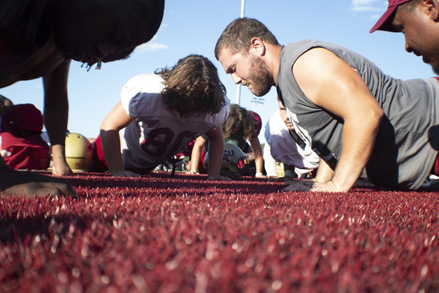 Nicholas Gonzalez, kinesiology sophomore, does 24 pushups to commemorate Robert Grey after football practice Sept. 19, 2018.