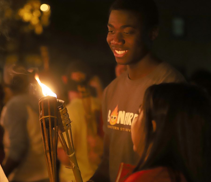 Students help light one anothers torch in the spirit of homecoming.