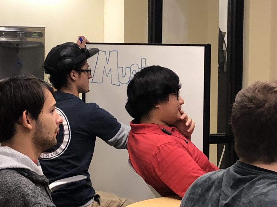 M.U.G. president and founder, Isaiah Edwards, writes the clubs information on a white board to notify potential members of the clubs meeting location.