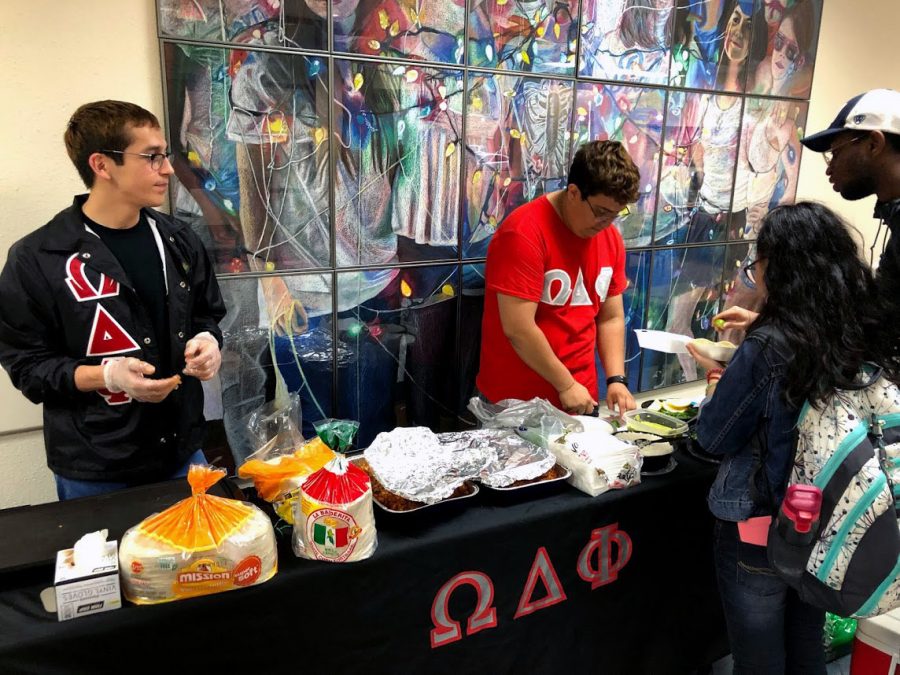 Members of Omega Delta Phi, Christopher Cruz and Michale Gonzales, sell tacos at ODPhajitas event April 24.