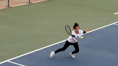 Lea on the court defends by hitting the ball back to her opponent.