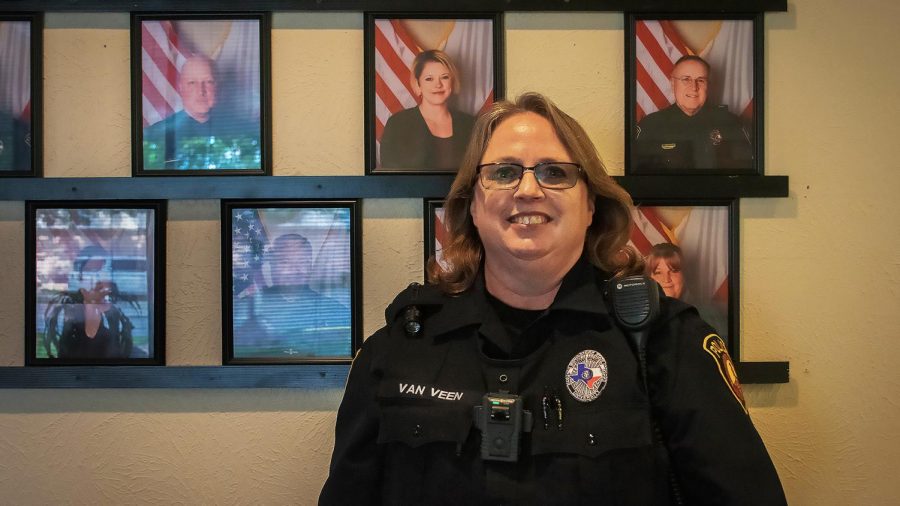 Officer Amy Van Veen poses alongside photos of other officers. Nov. 10