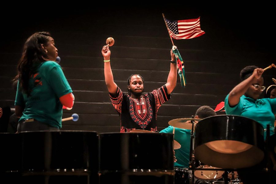 Mecahnical engineering junior Garvin Joseph holds up flags as the Black Steel pan group performs.