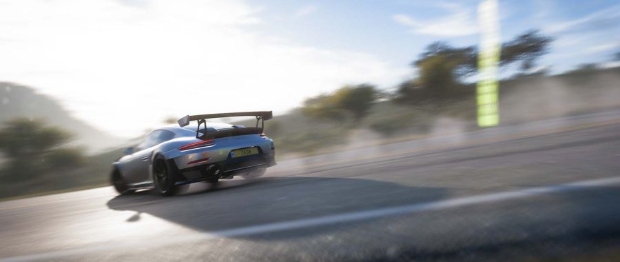 A Porsche 911 GT2 RS flies around a corner, leaving tire smoke its wake.