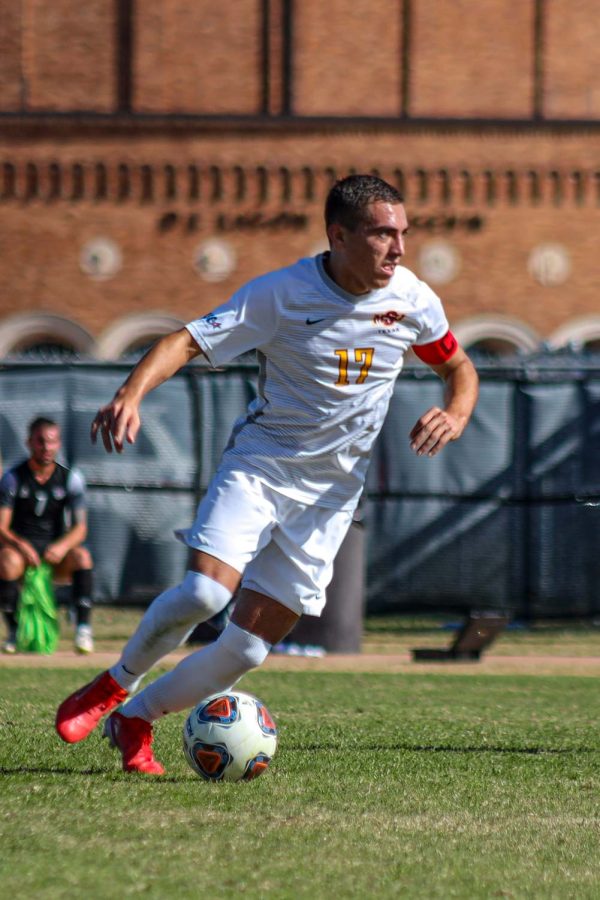 Kinesiology senior and midfielder Carlos Flores dribbles the ball against Lubbock Christian University.