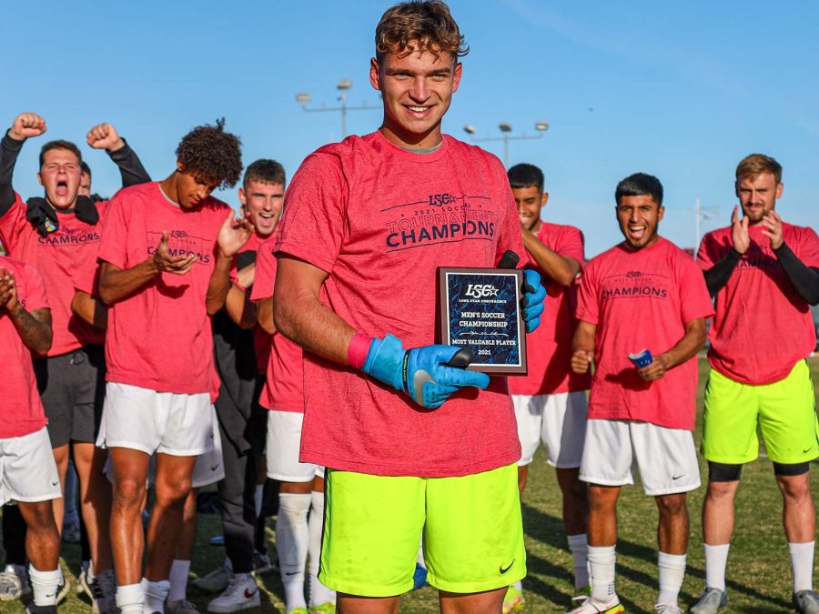 Marketing senior and goalkeeper Marc-Antoine Huzen holds a Most Valuable Player award after the Stangs game against Lubbock Christian University.