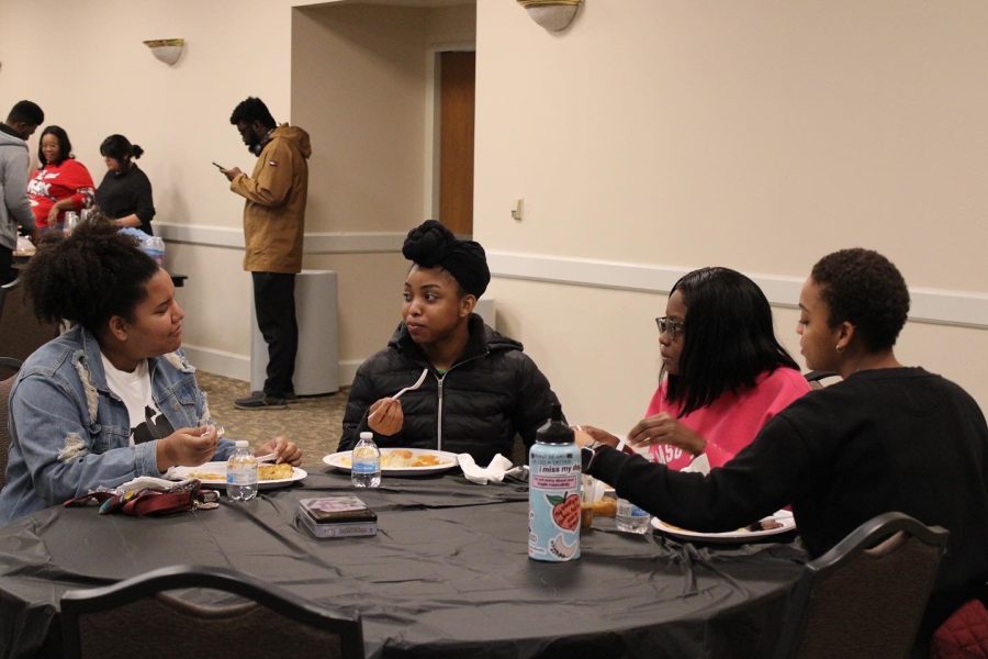 Students sit together and enjoy the food and music of the Soul Food Social, Feb. 17.