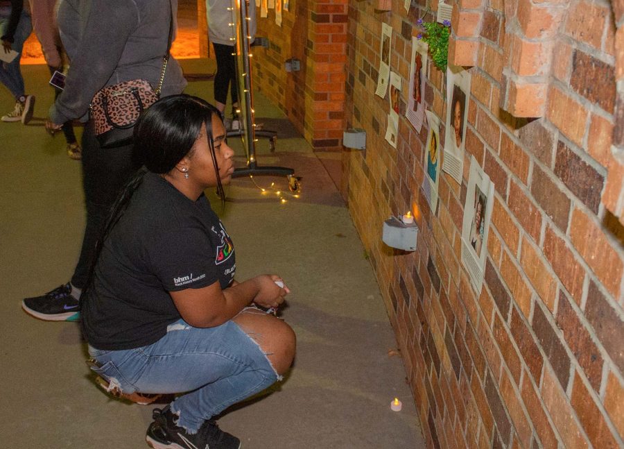 A student reads the story of a black woman killed by violence at the Say Her Name event, March 31.