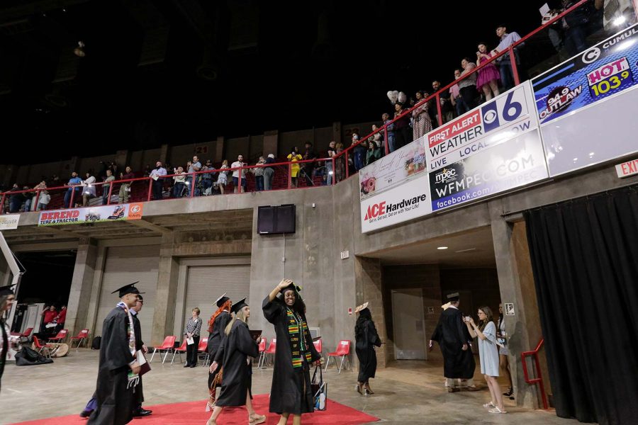 Friends and family line up above the exit to congratulate and cheer the graduates as they proceed out of the coliseum.