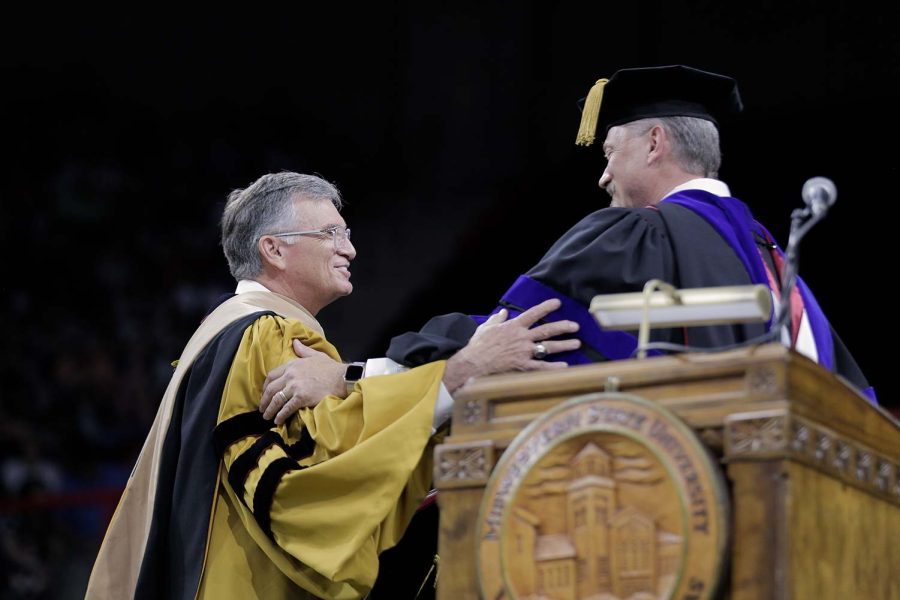 Professor Robert Forrester holds arms with interim president James Johnston as the former is named Hardin Professor for 2022.