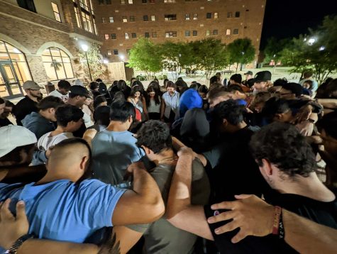 Students huddle together as political science and psychology sophomore Elaina Camp leads them in prayer.
